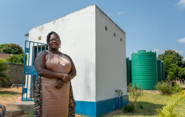 Ilda Timan in front of the toilet block