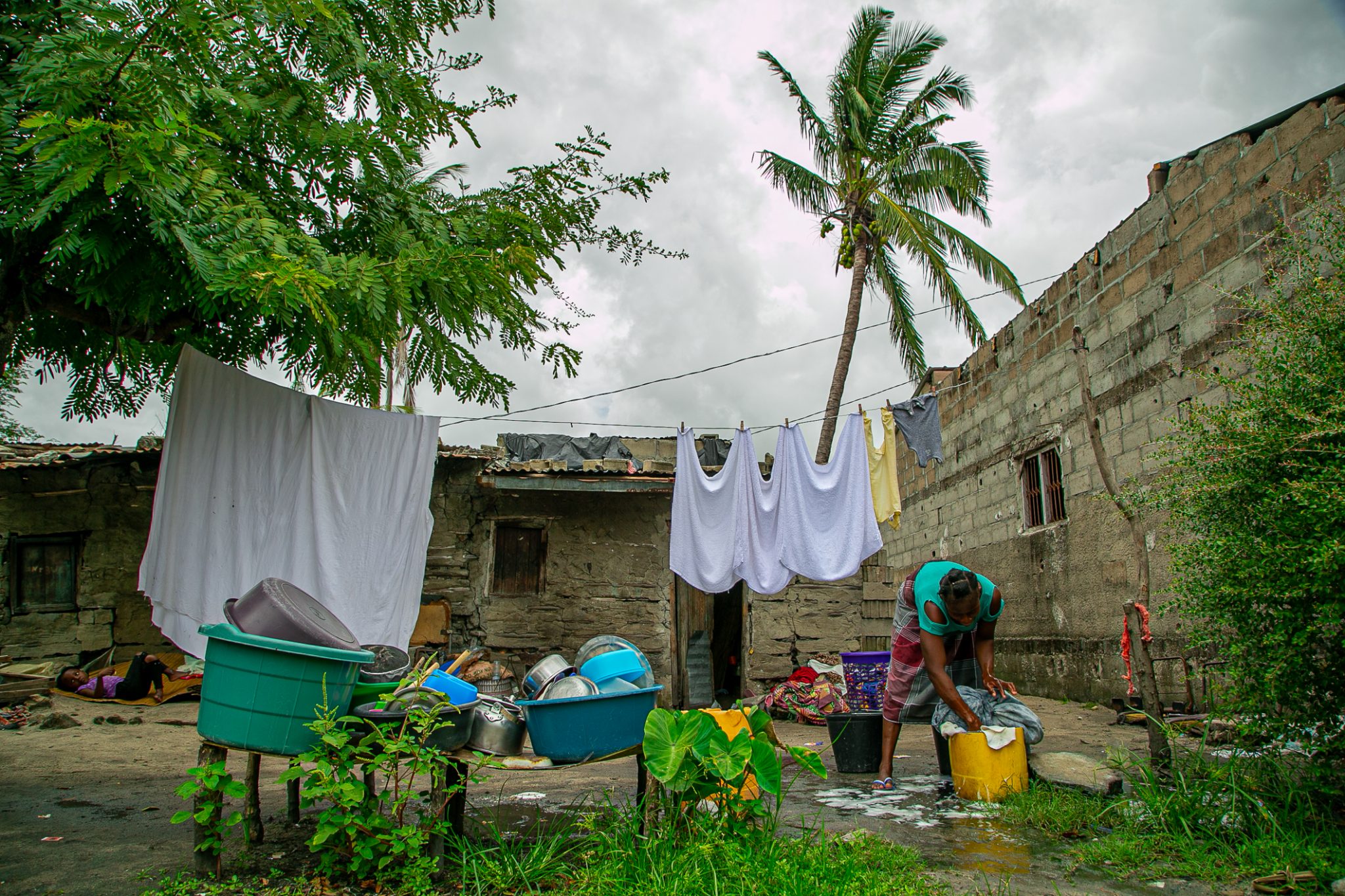 Henriqueta washes clothes outside her home in Beira