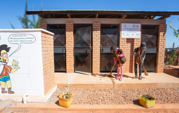 Students sweeping a school sanitation facility, Madagascar